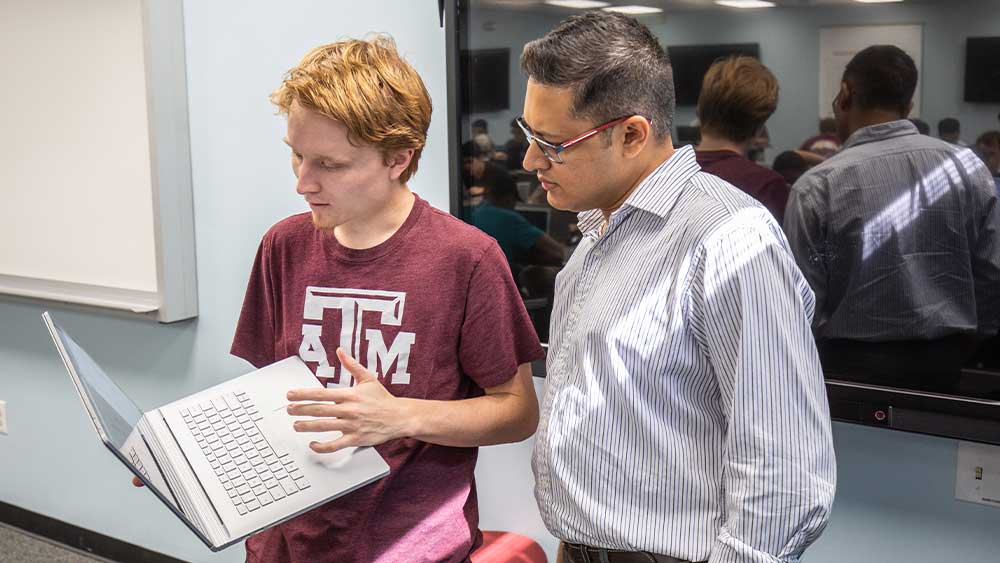 Guy showing professor laptop screen