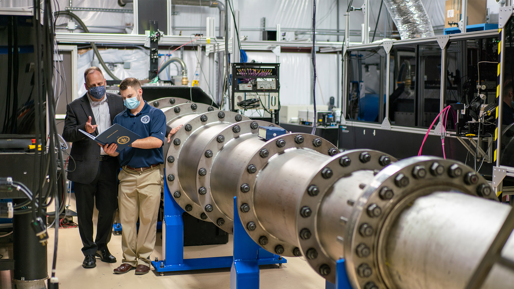 Dr. Bowersox and a graduate student looking over a binder in the hypersonics lab.