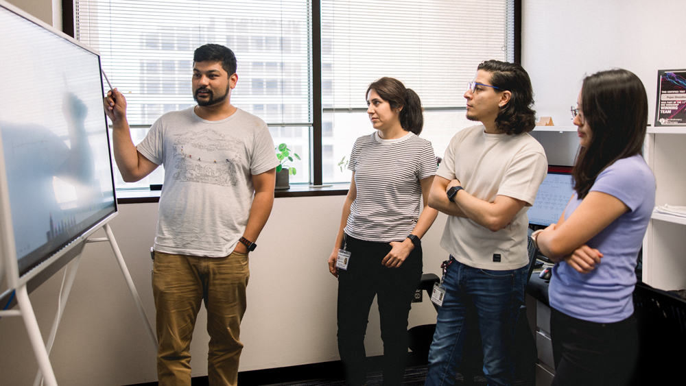 Four researchers studying a graph.