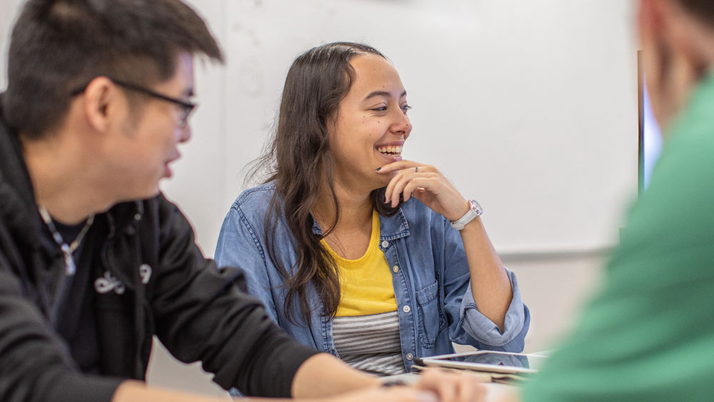 Computer engineering students laughing in a classroom.