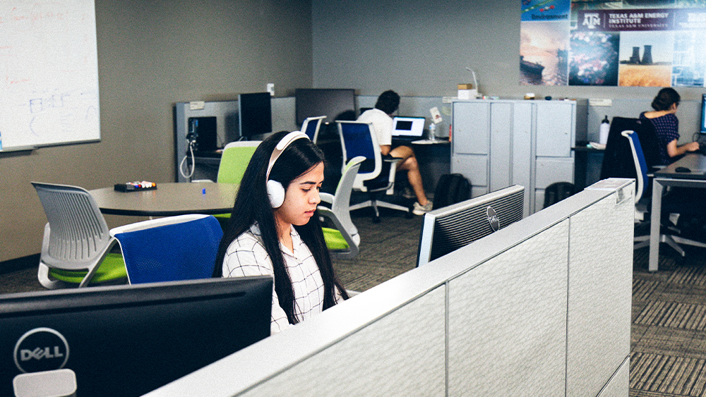 A student with headphones working in a computer lab 