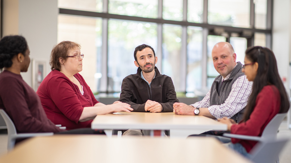 Multiple people sitting around a table 