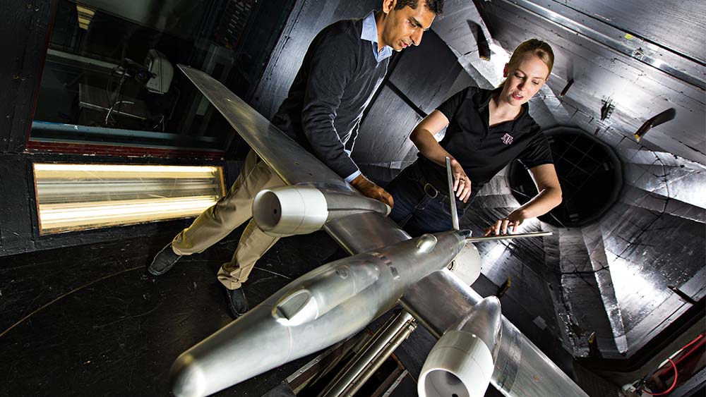 two aggie engineers working on an aircraft