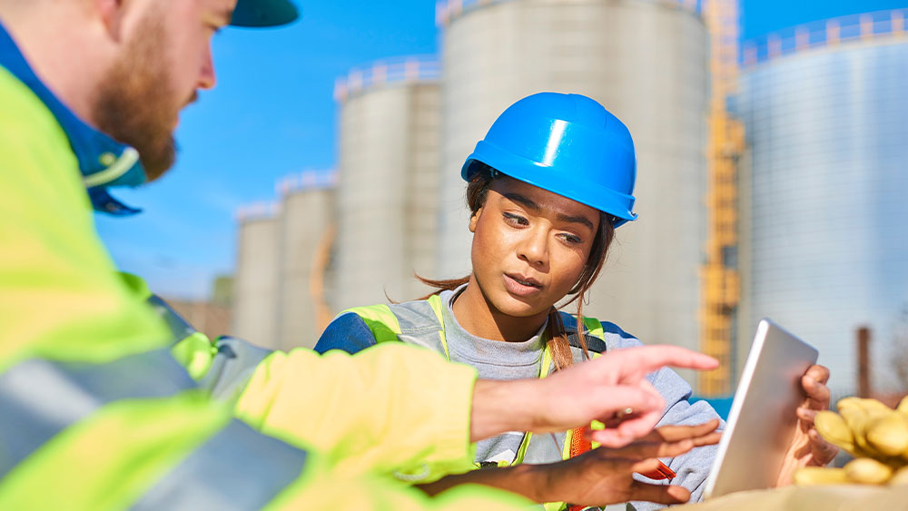 Safety Engineers in hardhats working collaboratively with plans.