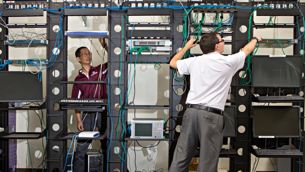 ETID faculty member working with an undergraduate student on computer hardware.