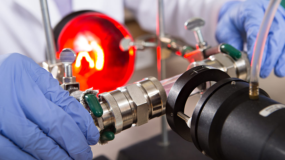 Close-up of a lab assistant examining a piece of equipment