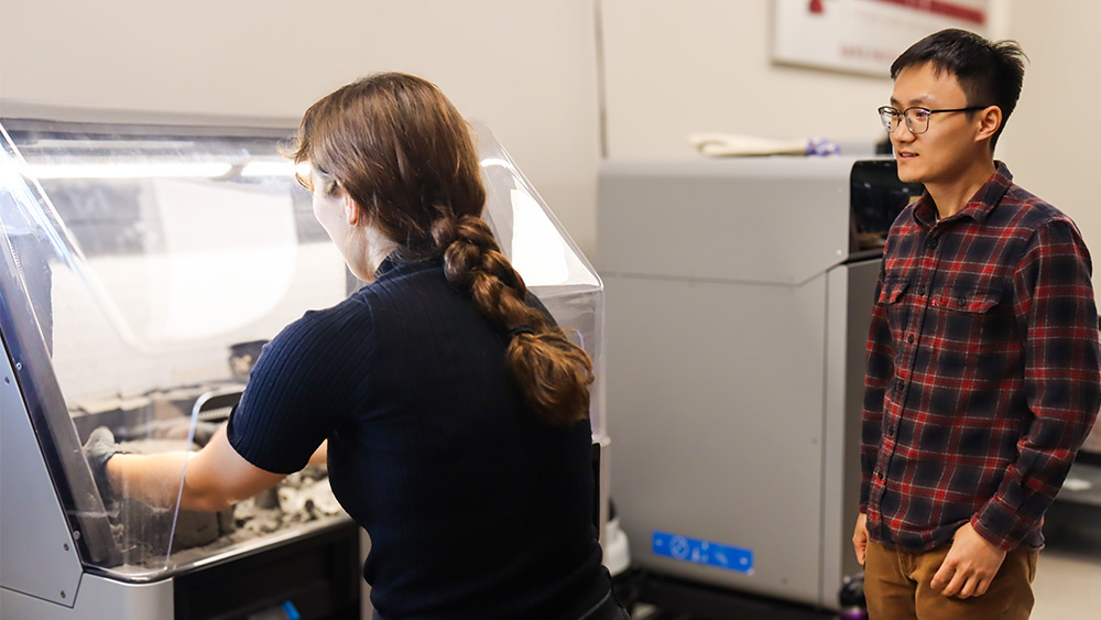 Students working at a machine in the rapid prototyping studio. 