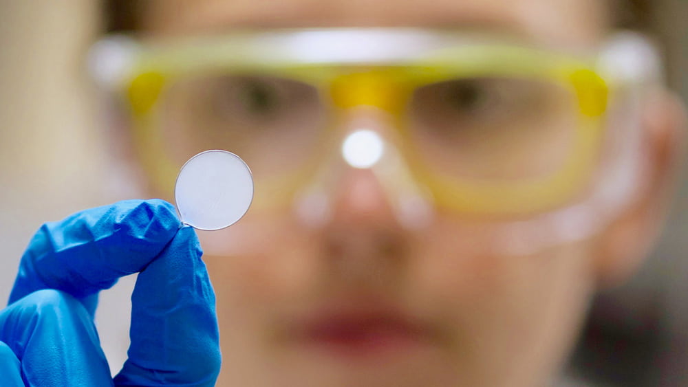 Researcher examines material in a lab.