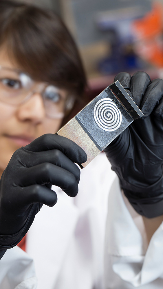 Jessica Zamarripa investigating the liquid metal powered shape memory alloy actuator in the lab.