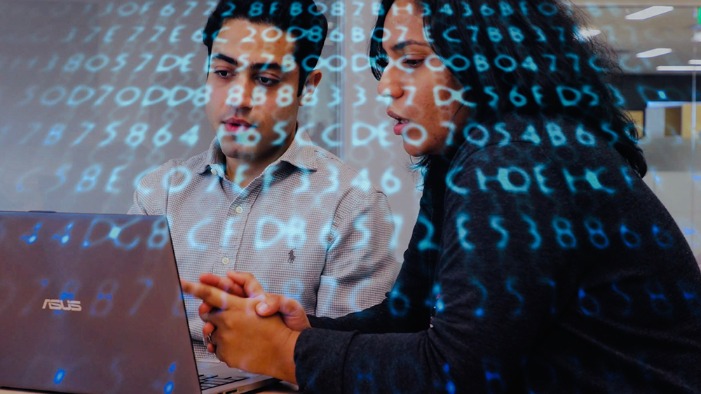 Texas A&M researchers work on a computer.