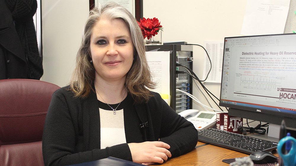 Dr. Berna Hascakir smiling and seated at her desk