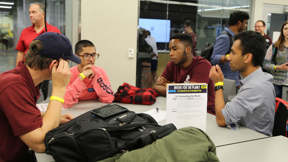 Team Hail No brainstorms around a table at Invent for the Planet