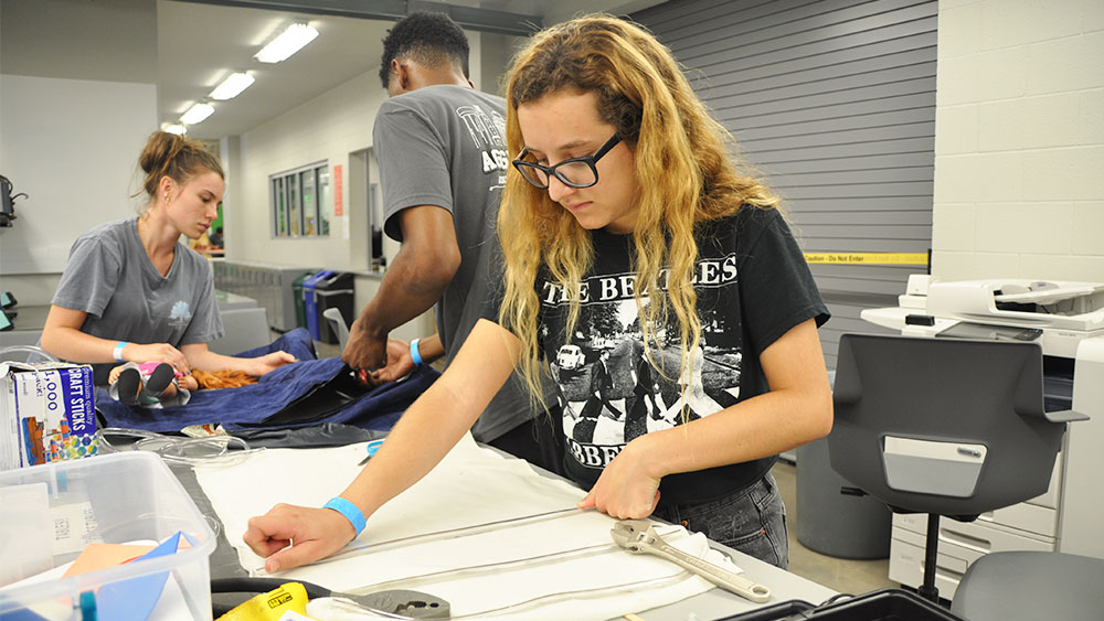 Female engineering student works on her team's solution to the Aggies Invent need statement.