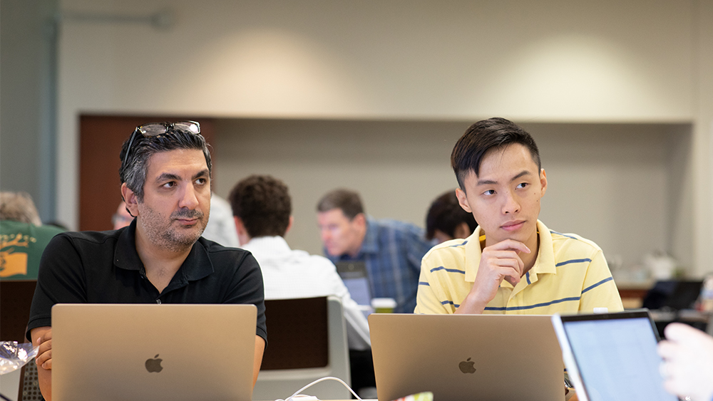 Professor and student working on computers. 