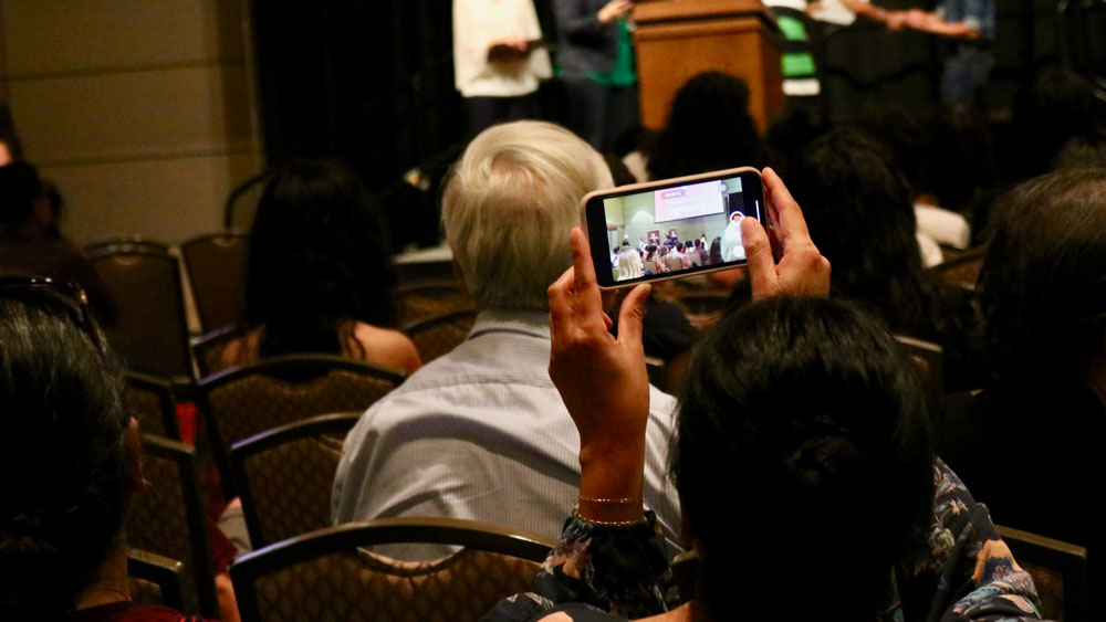 A parent recording the closing ceremony off a smartphone