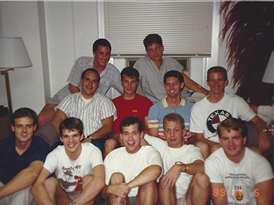 Group of men sit on a couch. 