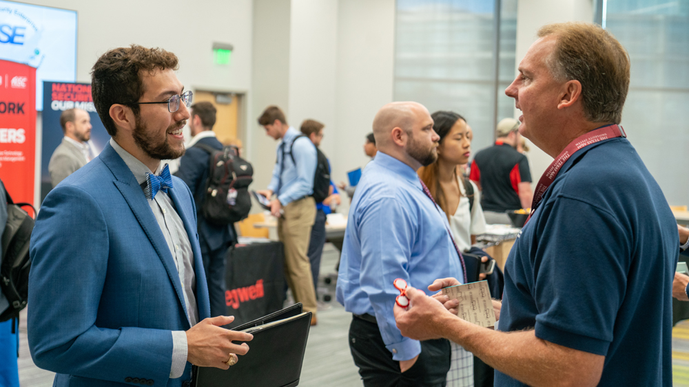 A student chats with a hiring manager at the NSE Day career fair.