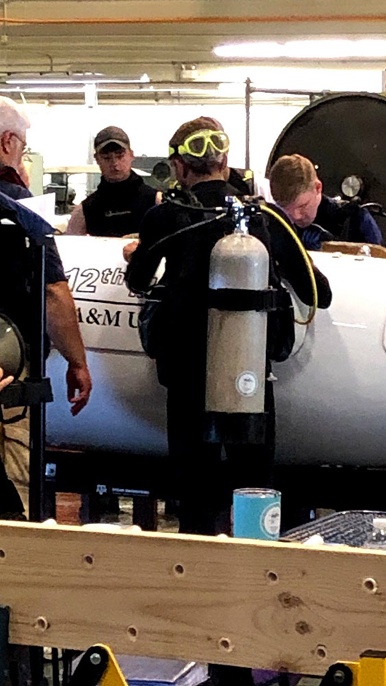 Human powered submarine team members work on their vehicle to prepare for an upcoming race.