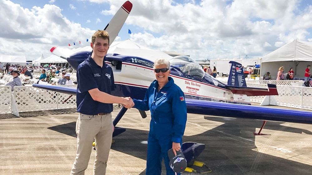 Texas A&amp;M University Aerospace Engineering student, Brady Allen, poses with Debby Rihn-Harvey in front of her plane at the Wings Over Houston Airshow.