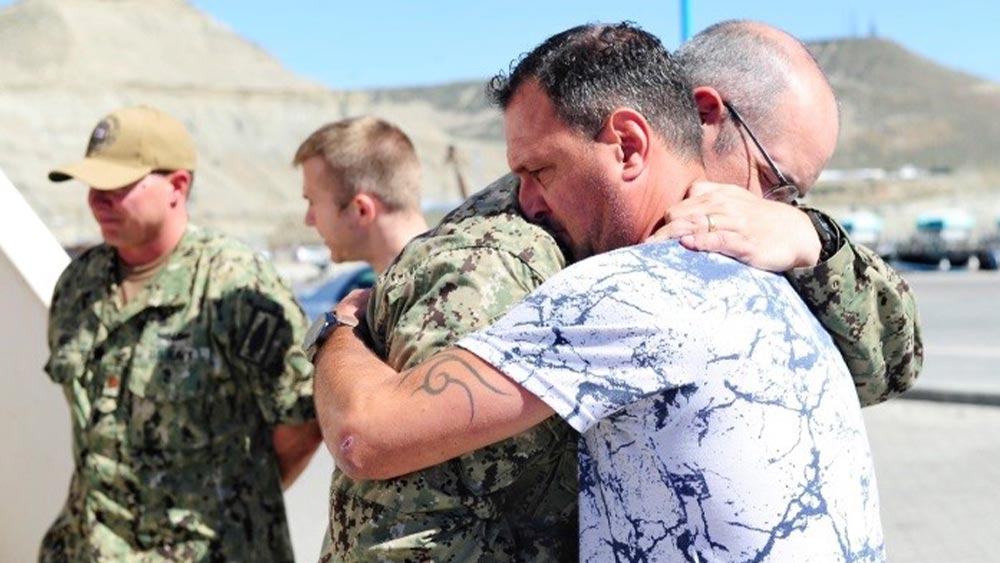 Richard Waer hugs the father of a lost submariner. 