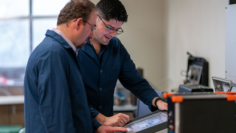 Dr. Eduardo Gildin and graduate student Enrique Losoya studying monitor of drilling advisory system for Department of Energy research project.