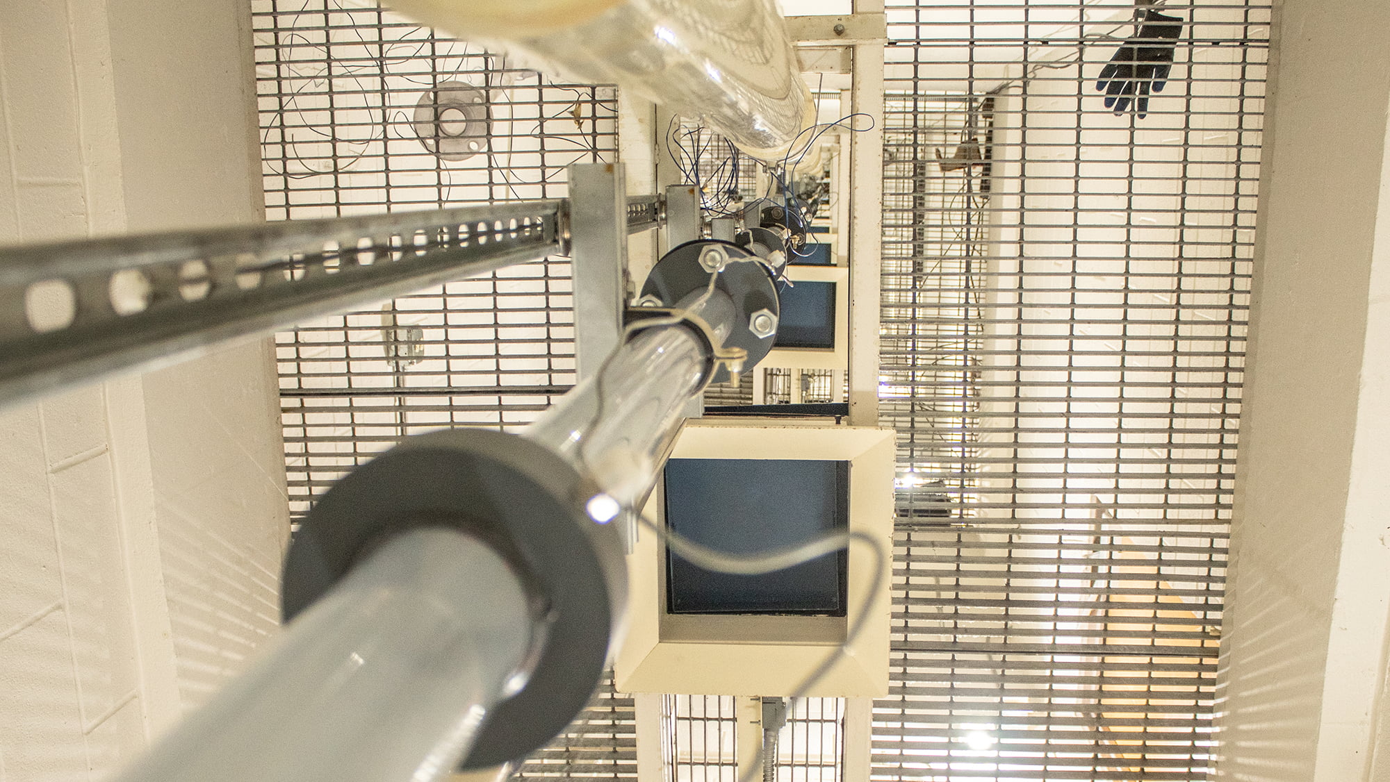 view of the pipes in the tower lab stretching up through the grated flooring levels above into a vertical illusion of infinity