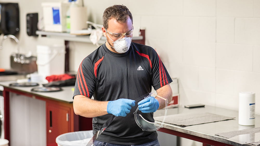 Technician in the Fischer Engineering Design Center assembling face shields.