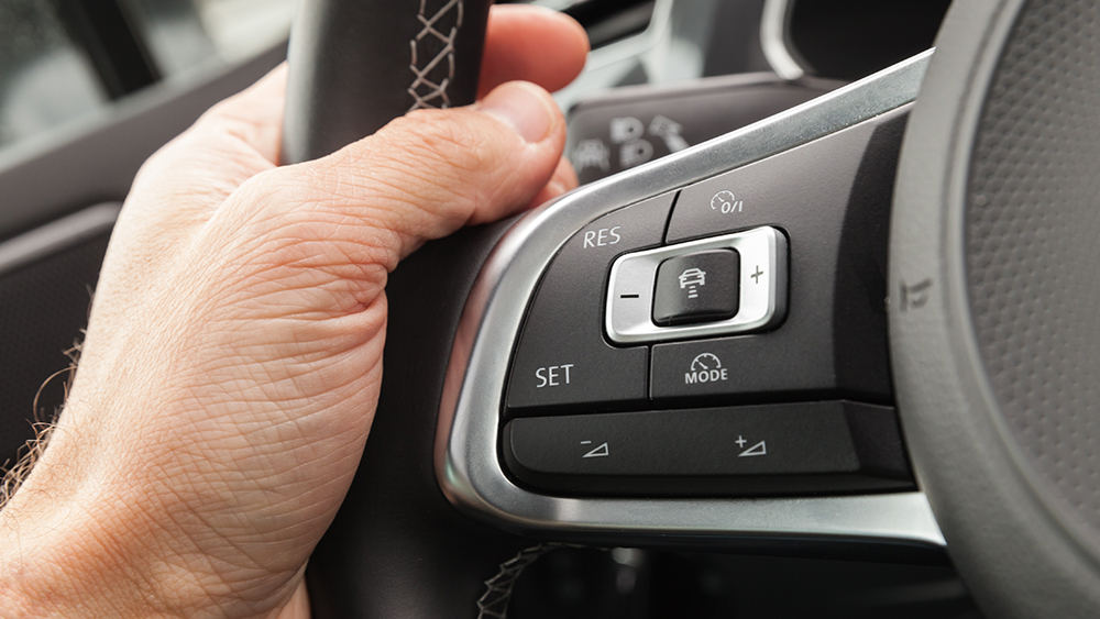 Hand resting on steering wheel of vehicle