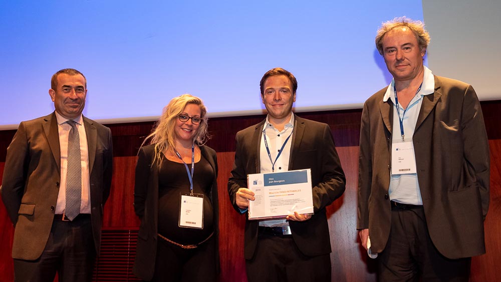 Four scientists stand together on a stage at an award ceremony. 