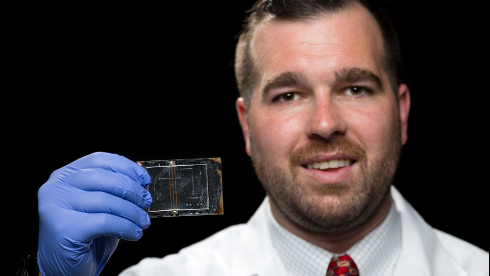 Student standing holding micro device