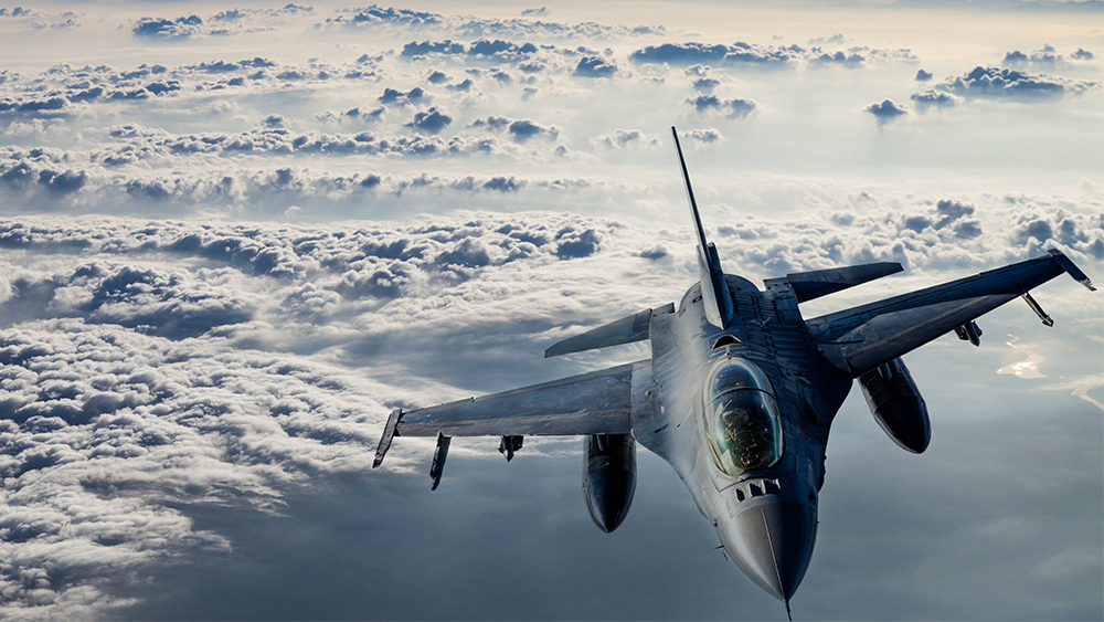 F-16 aircraft flying above the clouds