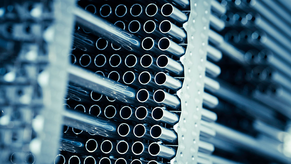 The inside details of a nuclear reactor show numerous rows of metal, cylindrical tubes. 