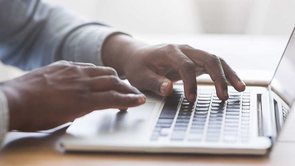 hands typing on computer laptop keyboard