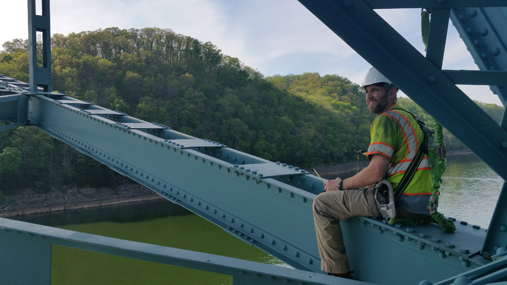 Dr. Matthew Yarnold performing a field experiment on a steel truss bridge.