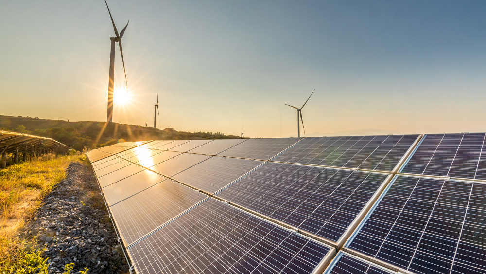 Wind turbines and solar panels in late afternoon. 