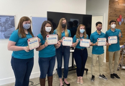 Students with masks on holding cerficates