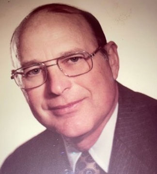  James W. “Bud” Porter, Jr. headshot in front of a blank wall. 