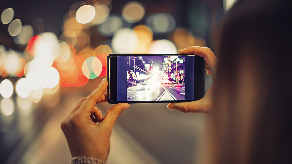 Woman taking picture of city with smartphone