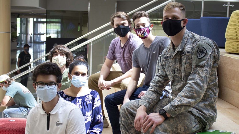 Group of students gathered on stairs wearing masks.