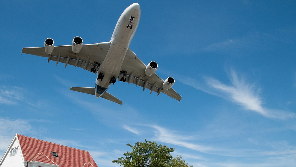 Plane landing and is shown flying over a residential area.