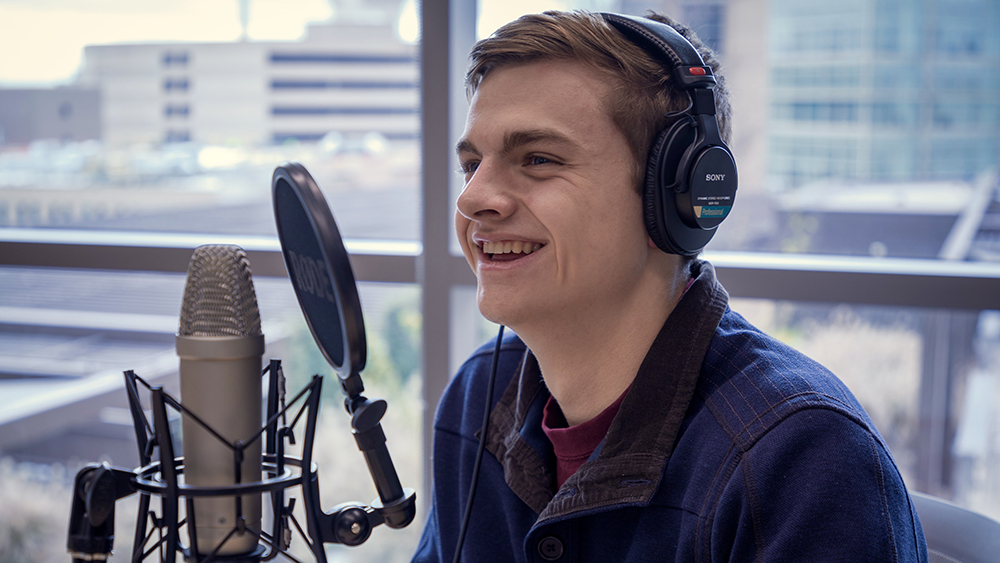 Drew DeHaven sitting in front of microphone