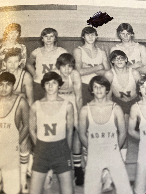 A black and white yearbook photo shows several boys in athletic clothing