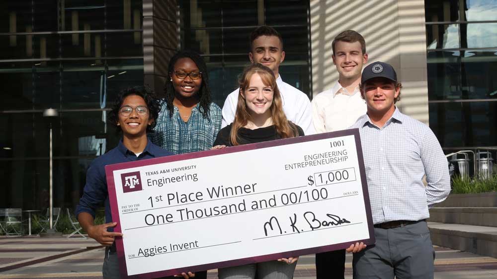 Group photo of 3 men and 2 women with giant check