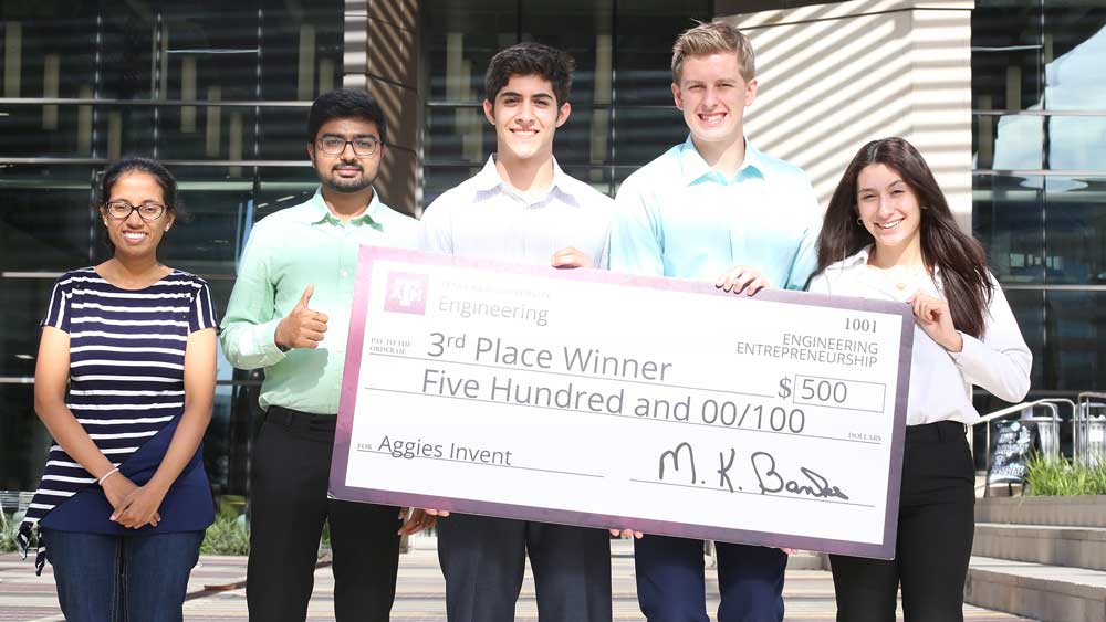 Group photo of 3 men and 2 women with giant check