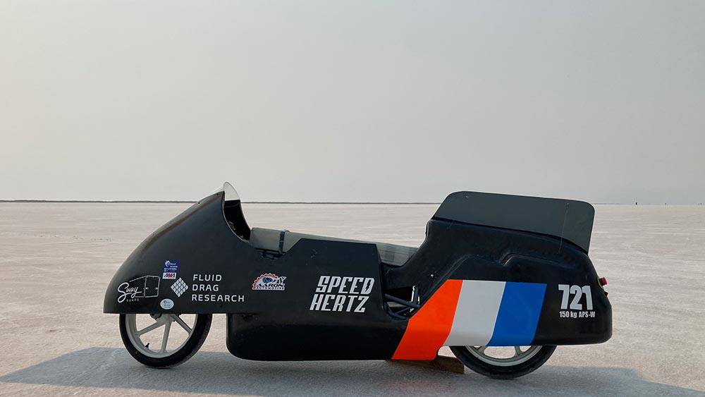 a black electric motorcycle sits stationary against the horizon of the Bonneville salt flats