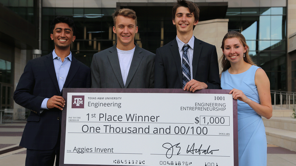 Group standing with big check