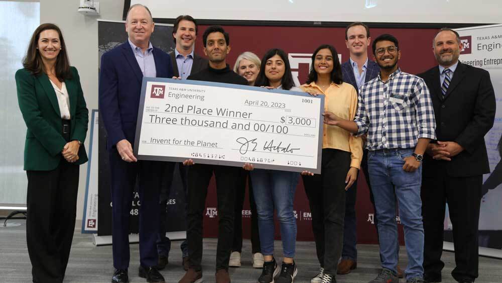 The second-place team, FinDiesel from Pakistan, and judges pose with an oversized $3,000 check.