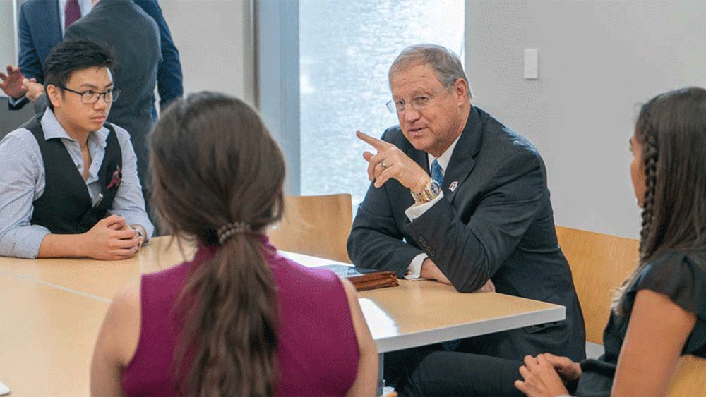 Man talking to students at a table.