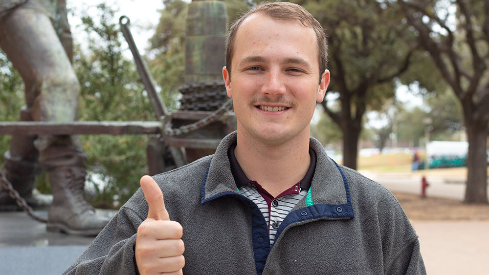 Blake Ropers smiling while standing outdoors on Texas A&M University campus