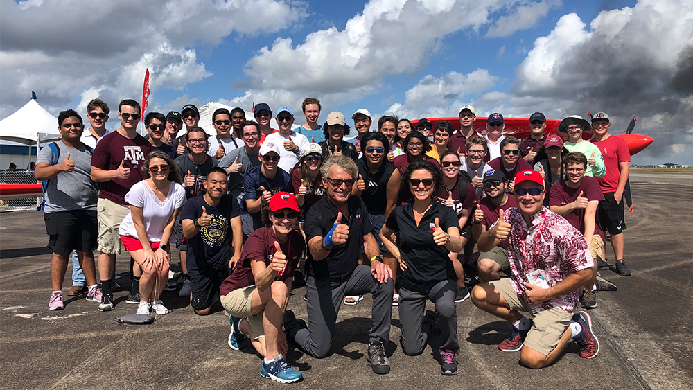 Brad Worsham in a group photo with students at an outdoors aerospace event.